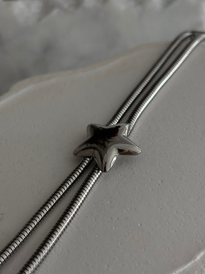 Silver star-shaped clasp on a textured surface