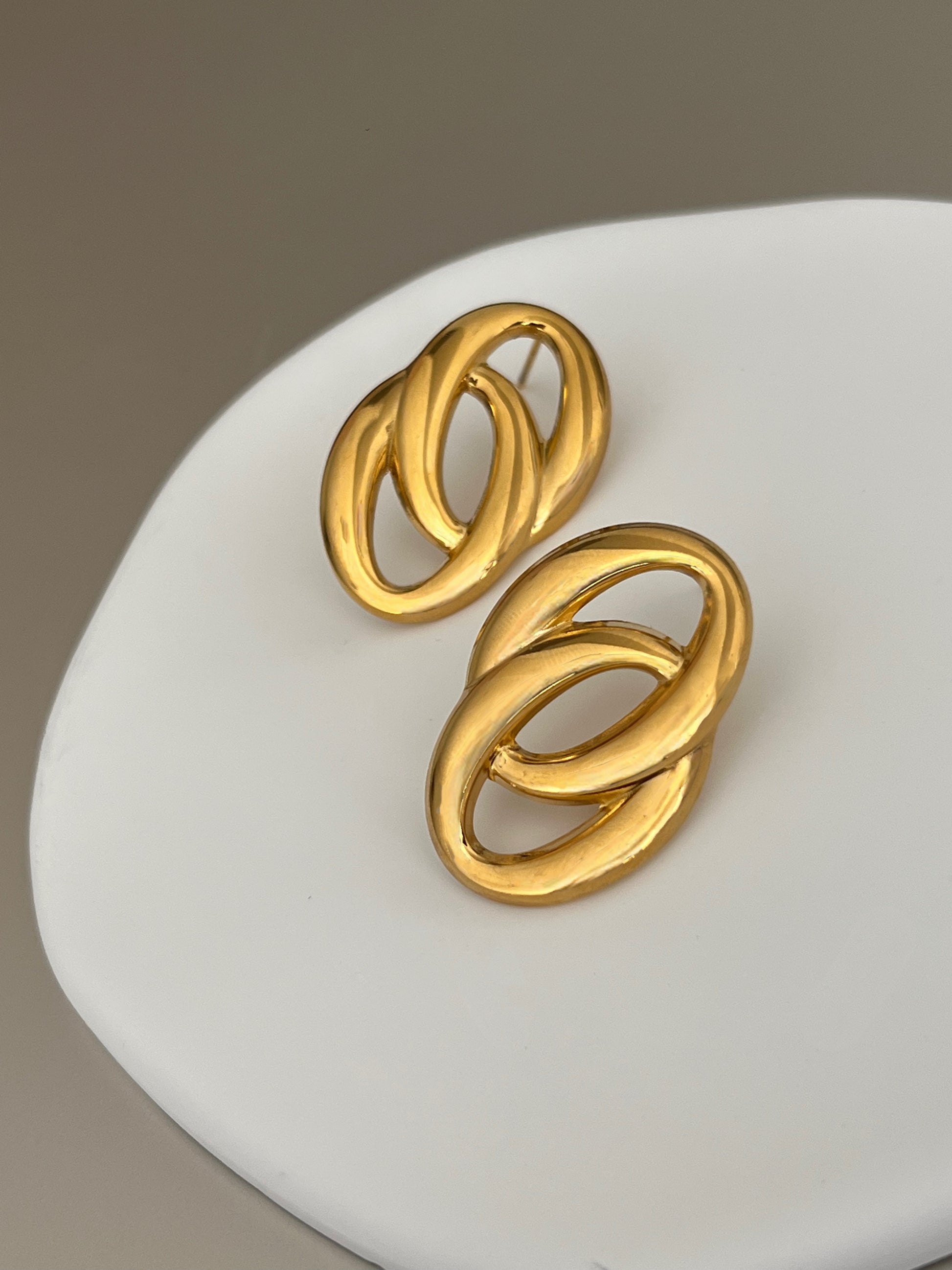 Vitta Link earrings on a white surface with a neutral background