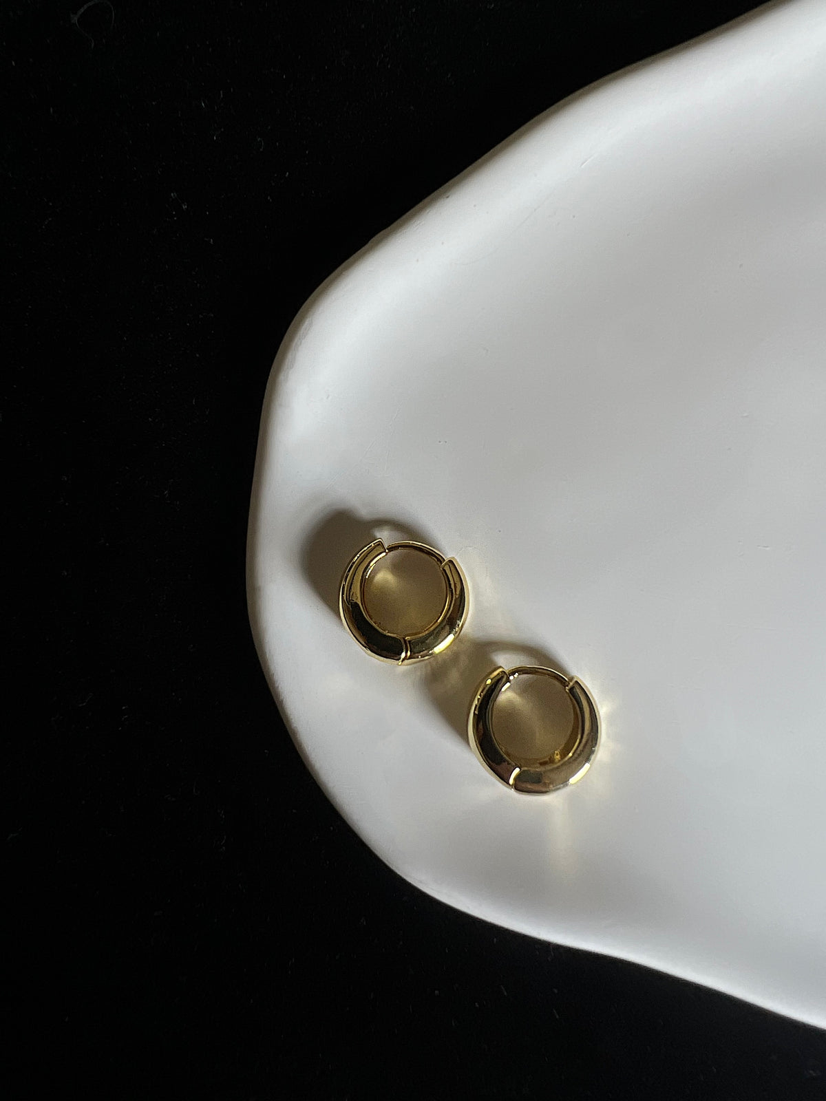 Lumi Mini gold huggie earrings close-up
