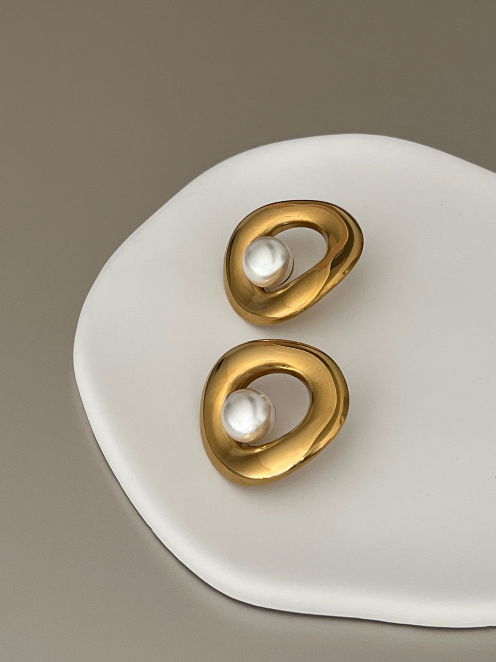 Sol Halo earrings, an EverLuxe best seller, on a white plate.