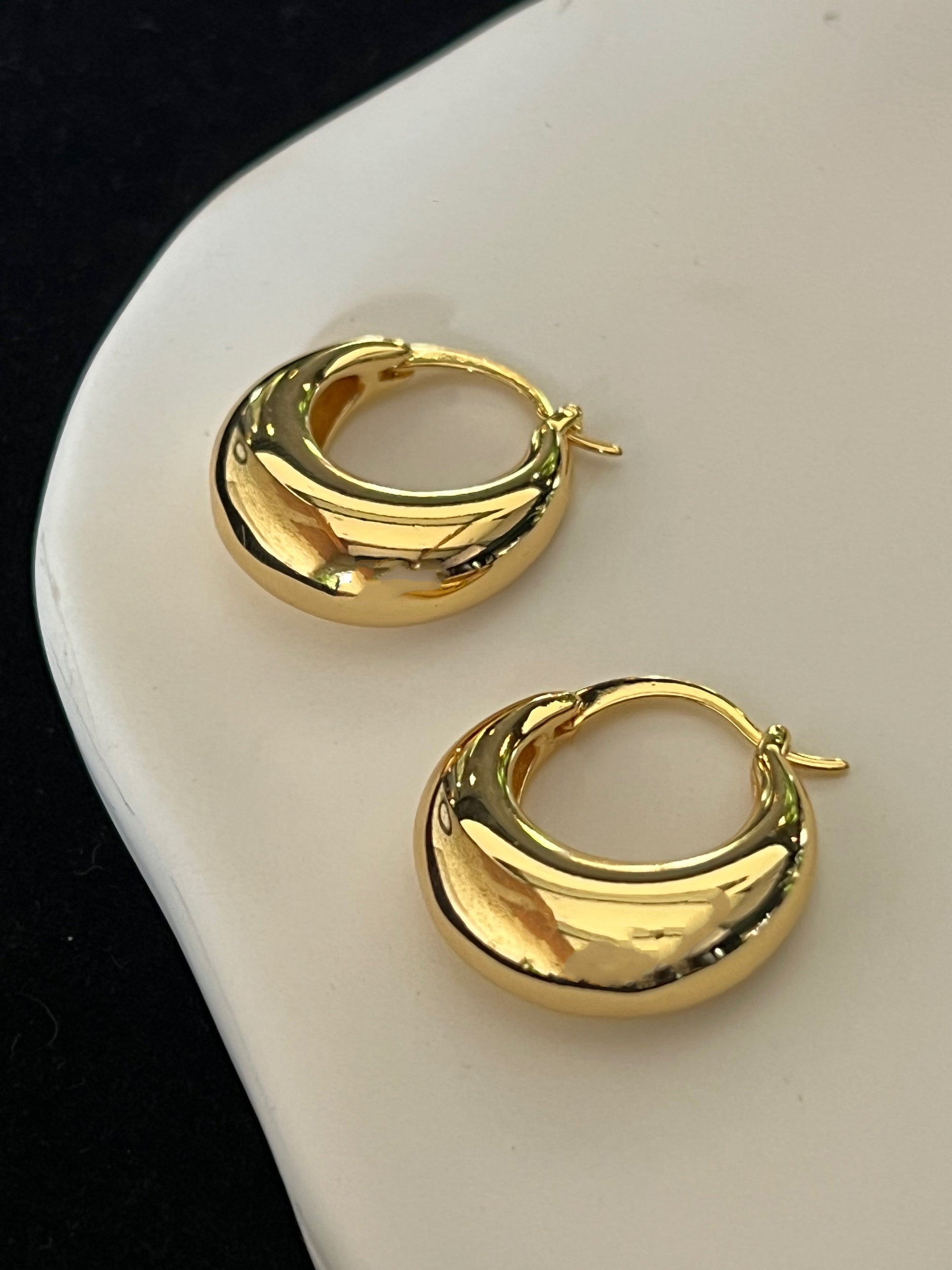 Bold gold earrings with polished puffed shape